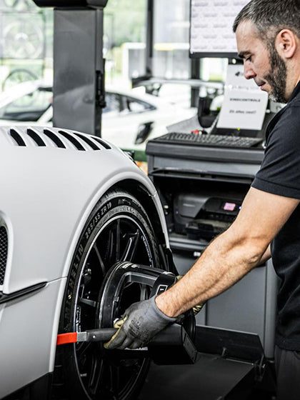 Technician fitting a new tire with professional equipment at Heinz Performance